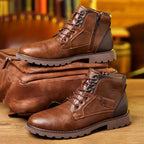 Bottes en cuir marron pour homme avec fermeture éclair, posées sur un sac en cuir assorti. Chaussures robustes, style décontracté, mode masculine.