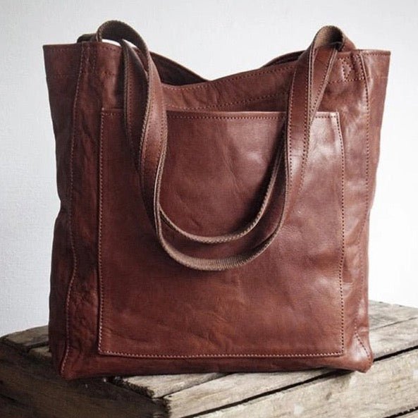 Sac en cuir marron sur une table en bois, design élégant et pratique, idéal pour le quotidien. Accessoire mode tendance, sac à main femme.