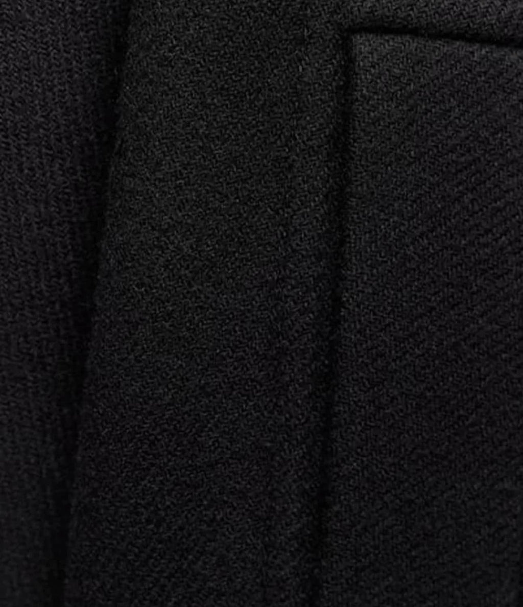 Texture de tissu noir en gros plan, montrant un motif tissé serré. Idéal pour vêtements élégants, costumes, mode haute couture.