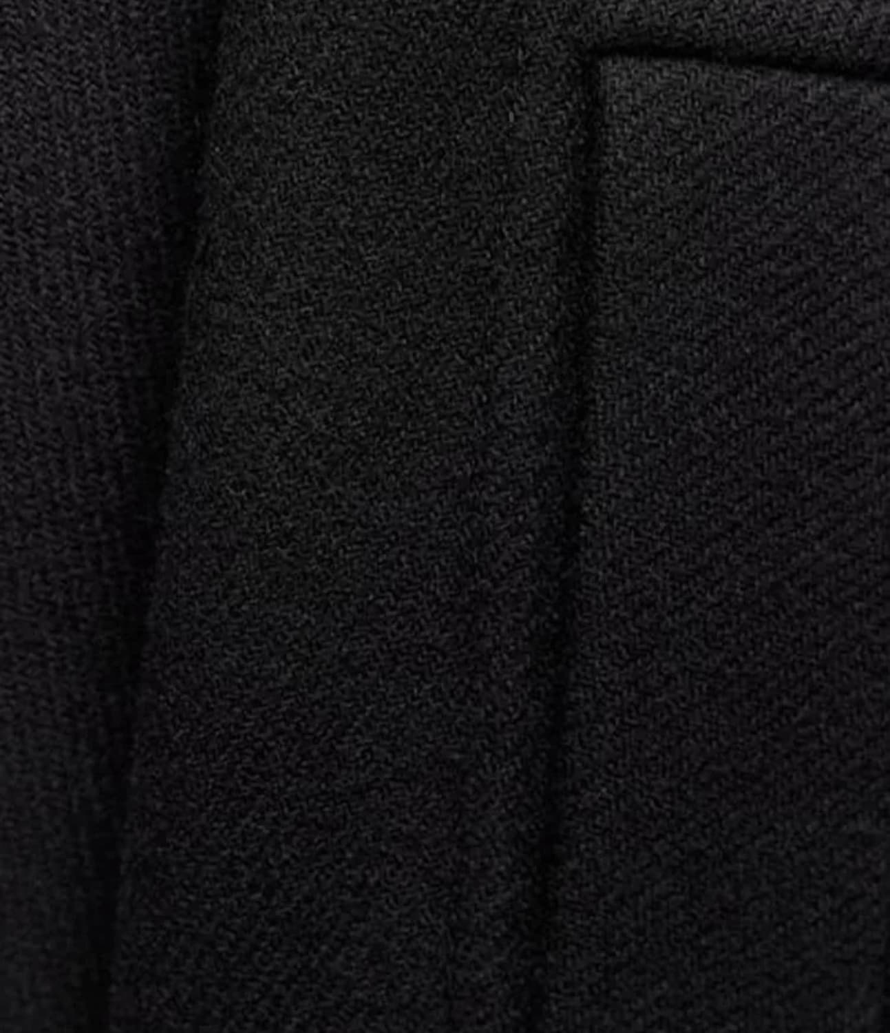 Texture de tissu noir en gros plan, montrant un motif tissé serré. Idéal pour vêtements élégants, costumes, mode haute couture.