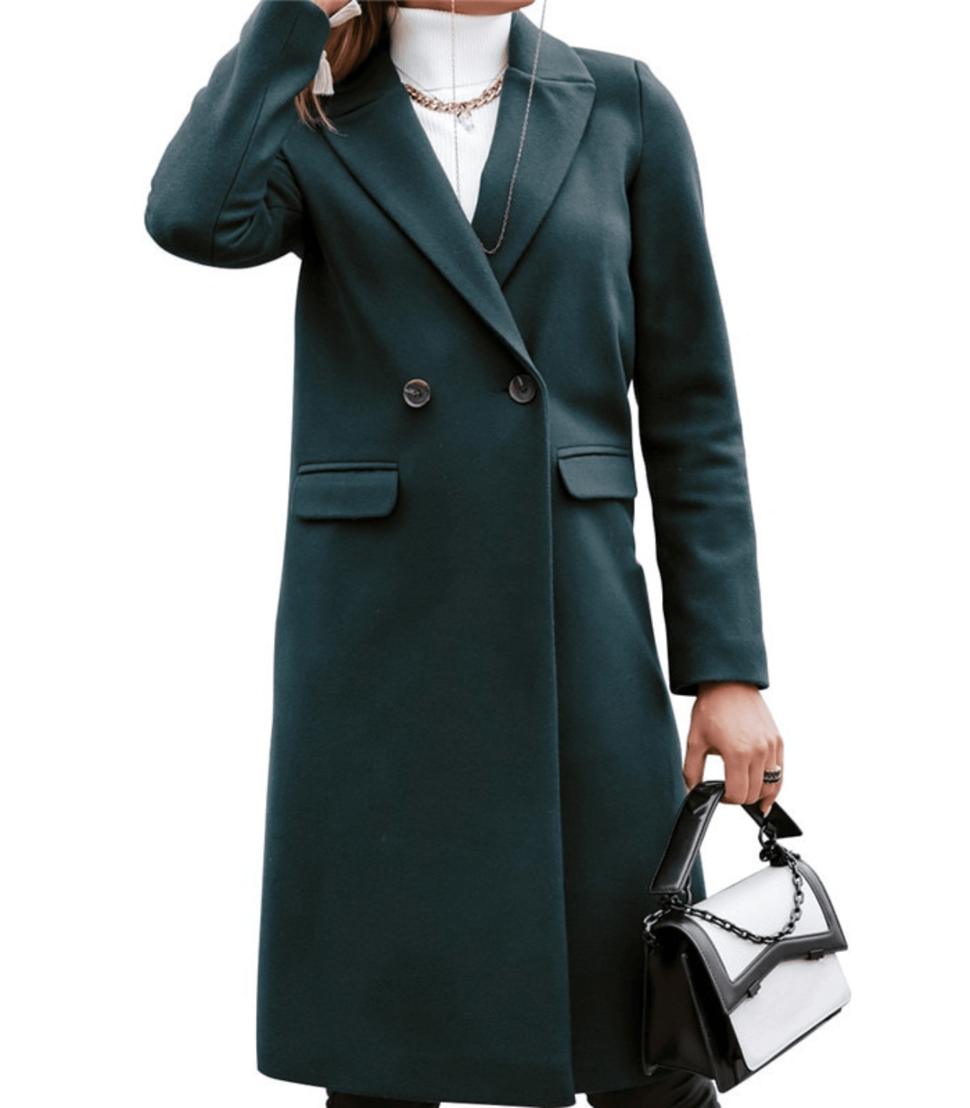Manteau long vert foncé élégant pour femme, avec col à revers et boutons, porté avec un sac à main noir et blanc. Mode automne chic.