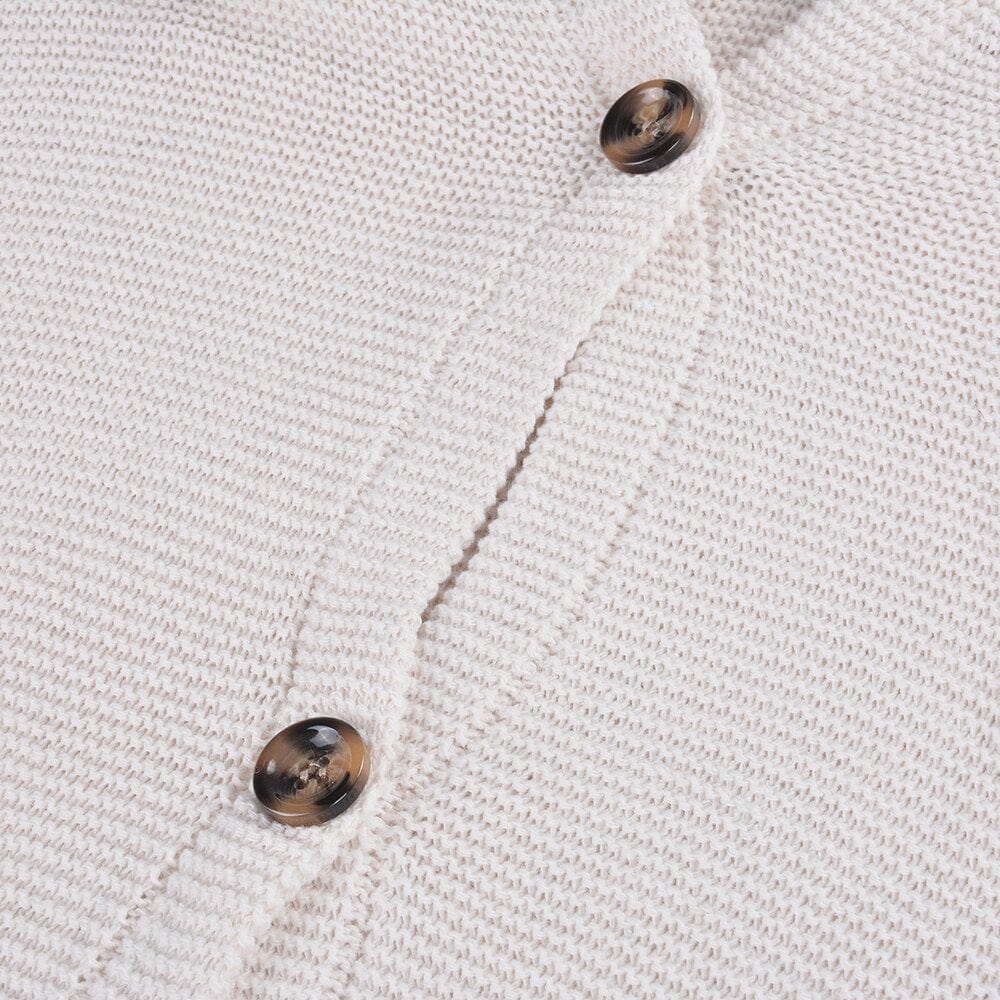 Gros plan sur un cardigan en maille beige avec boutons marron. Mode automne, vêtement chaud, style décontracté, tendance hiver.