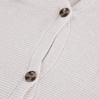 Gros plan sur un cardigan en maille beige avec boutons marron. Mode automne, vêtement chaud, style décontracté, tendance hiver.