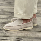 Pantalon beige et mocassins en daim beige sur plancher en bois. Chaussures élégantes pour homme, style décontracté chic, mode masculine tendance.