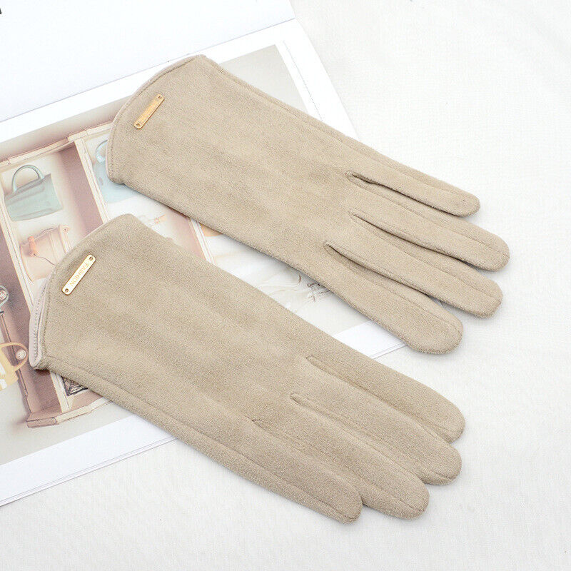 Gants en daim beige élégants posés sur un livre ouvert, parfaits pour l'hiver. Accessoire de mode chic et tendance pour femmes.