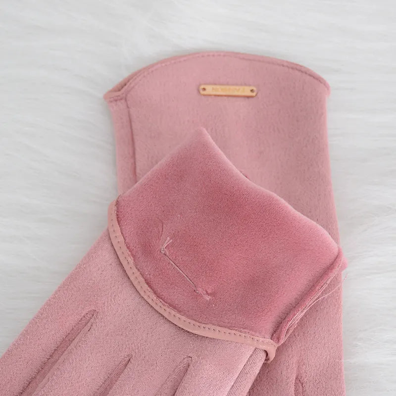 Gants en daim rose posés sur une surface blanche, élégants et doux, parfaits pour l'hiver. Accessoire de mode féminin tendance et chic.