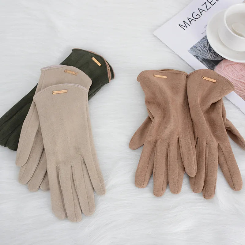 Gants en daim beige et marron sur fond blanc, à côté d'une tasse et d'un magazine. Accessoires d'hiver élégants et confortables.