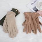 Gants en daim beige et marron sur fond blanc, à côté d'une tasse et d'un magazine. Accessoires d'hiver élégants et confortables.