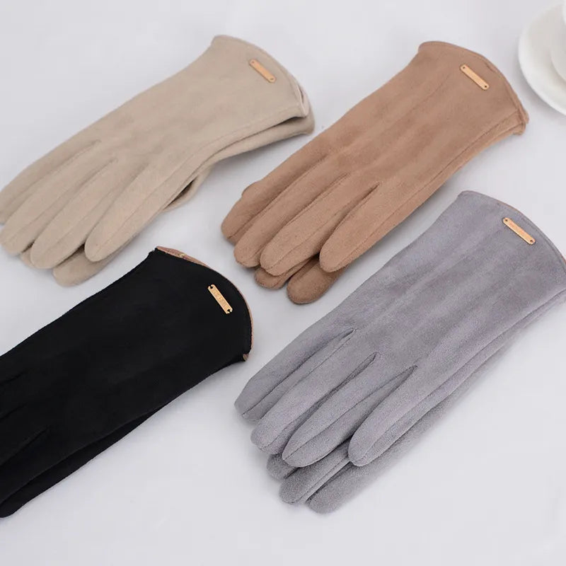Quatre paires de gants en daim pour femmes, couleurs beige, marron, noir et gris, élégants et chauds, posés sur une surface blanche.