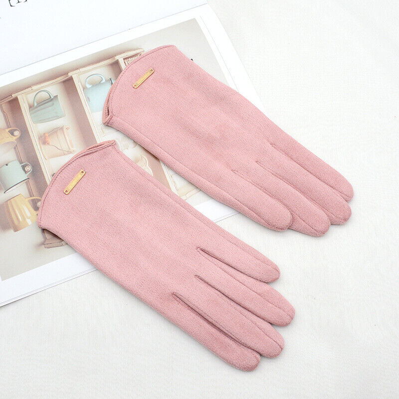 Gants en daim rose posés sur un magazine, élégants et modernes, parfaits pour l'hiver. Accessoire de mode féminin, tendance et chic.