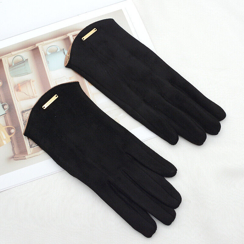 Gants noirs élégants en tissu, posés sur une surface blanche avec un magazine en arrière-plan. Accessoire de mode chic pour l'hiver.