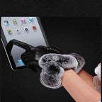 Gants en cuir noir avec fourrure grise touchant un écran tactile de tablette. Accessoire élégant pour l'hiver, compatible avec appareils numériques.