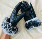 Gants en cuir noir avec doublure en fausse fourrure blanche et grise, posés sur un fond clair. Accessoire d'hiver élégant et chaud.