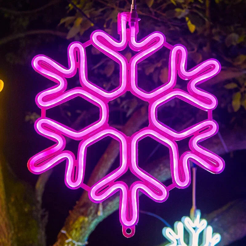 Flocon de neige néon rose suspendu, éclairage décoratif lumineux, ambiance festive nocturne, arbre en arrière-plan.