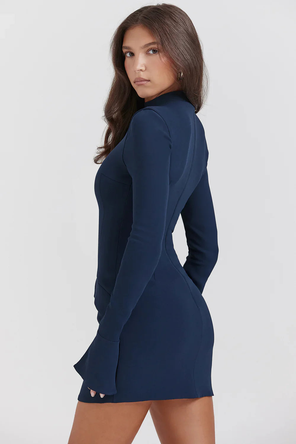 Femme portant une robe moulante bleu marine à manches longues, élégante et moderne, idéale pour une soirée ou un événement chic.