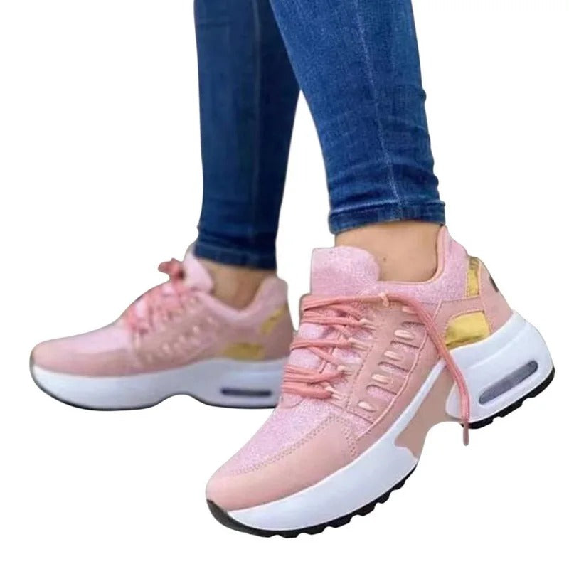 Baskets roses pour femme avec semelle épaisse blanche, détails dorés, portées avec un jean bleu. Chaussures tendance et confortables.