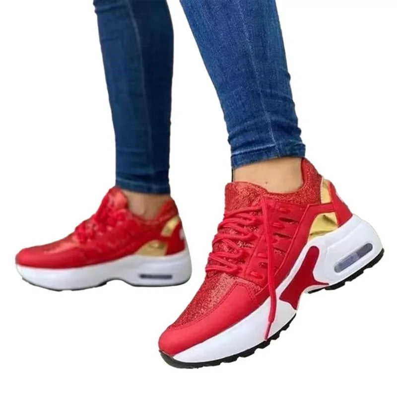 Baskets rouges et blanches pour femme, design moderne avec semelle épaisse, portées avec un jean bleu. Mode féminine, chaussures tendance.