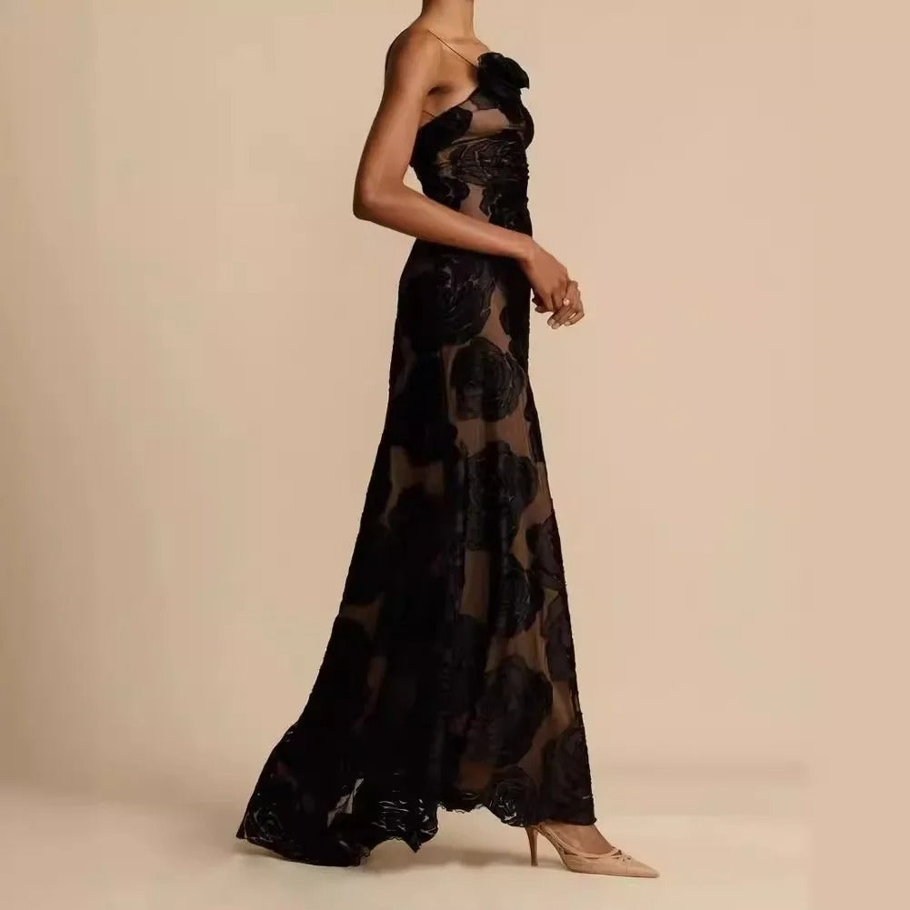 Robe longue élégante en dentelle noire transparente, motif floral, sans manches, portée avec des talons beiges. Mode féminine chic et sophistiquée.