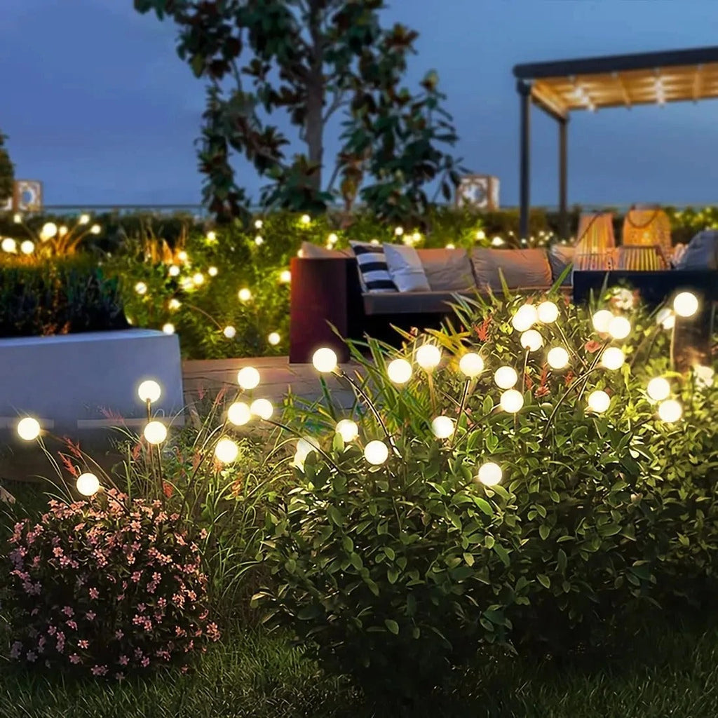 Jardin illuminé avec guirlandes lumineuses LED, terrasse en bois, mobilier extérieur moderne, ambiance nocturne, éclairage décoratif.