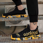 Chaussures de sport noires et jaunes pour homme, semelle camouflage, design moderne, portées sur un escalier métallique. Sneakers tendance et confortables.