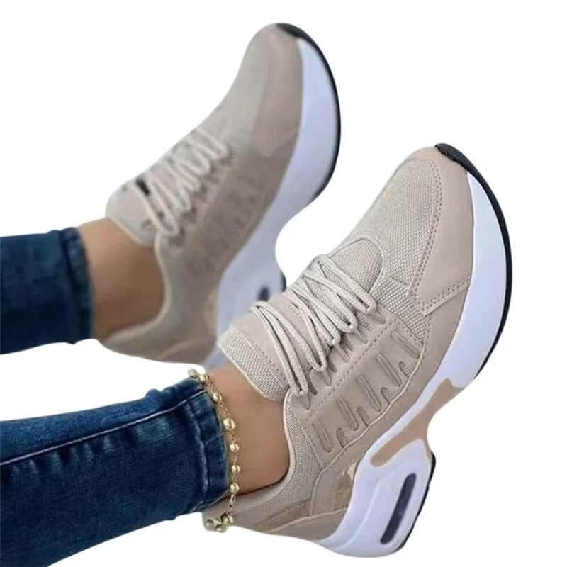 Baskets beiges pour femme, design moderne, semelle épaisse blanche, portées avec un jean. Chaussures de sport tendance, confortables et élégantes.