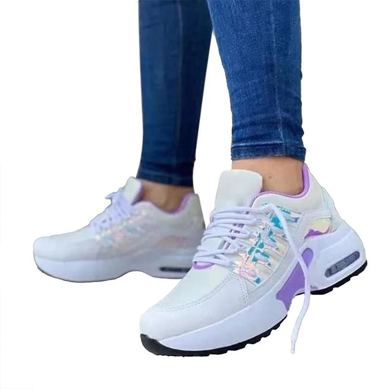 Baskets blanches et violettes pour femme, design moderne, semelle épaisse, portées avec un jean bleu. Chaussures de sport tendance et confortables.