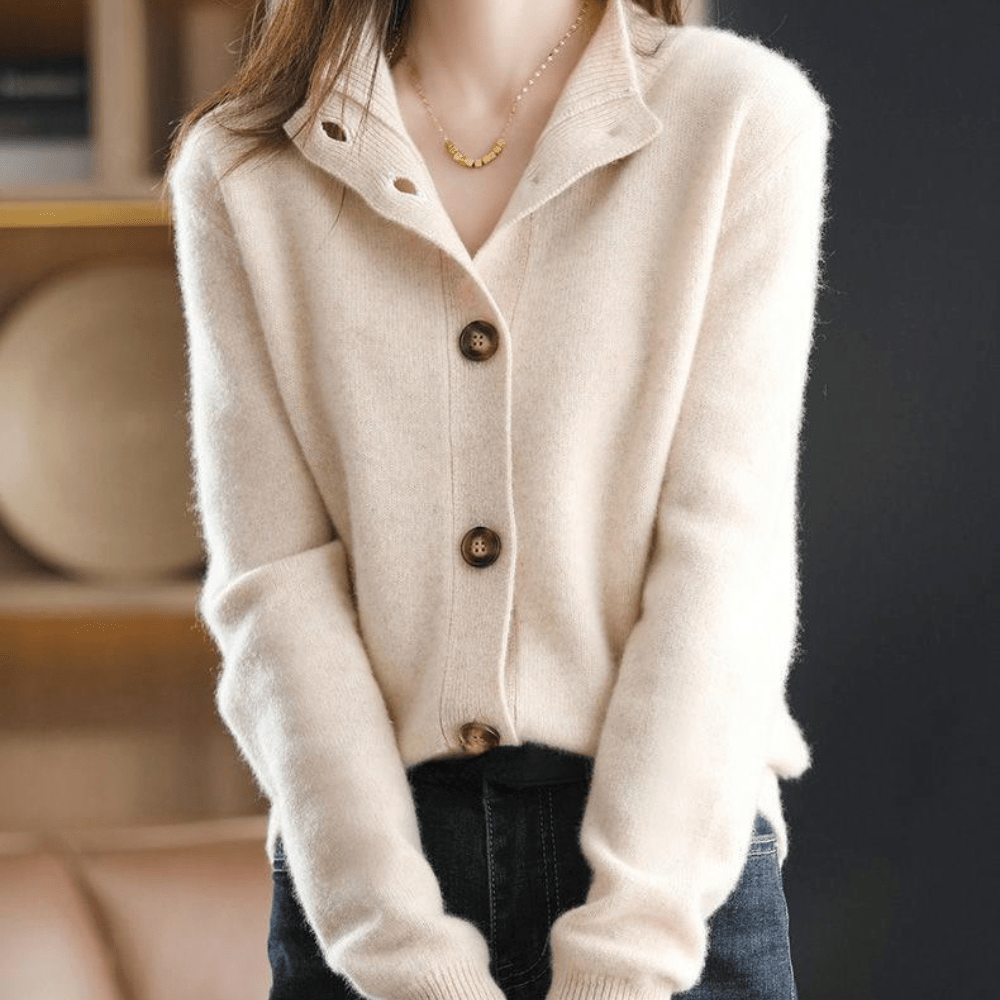 Femme portant un cardigan beige en laine avec boutons en bois, col ouvert, manches longues, style décontracté. Mode automne-hiver élégante.