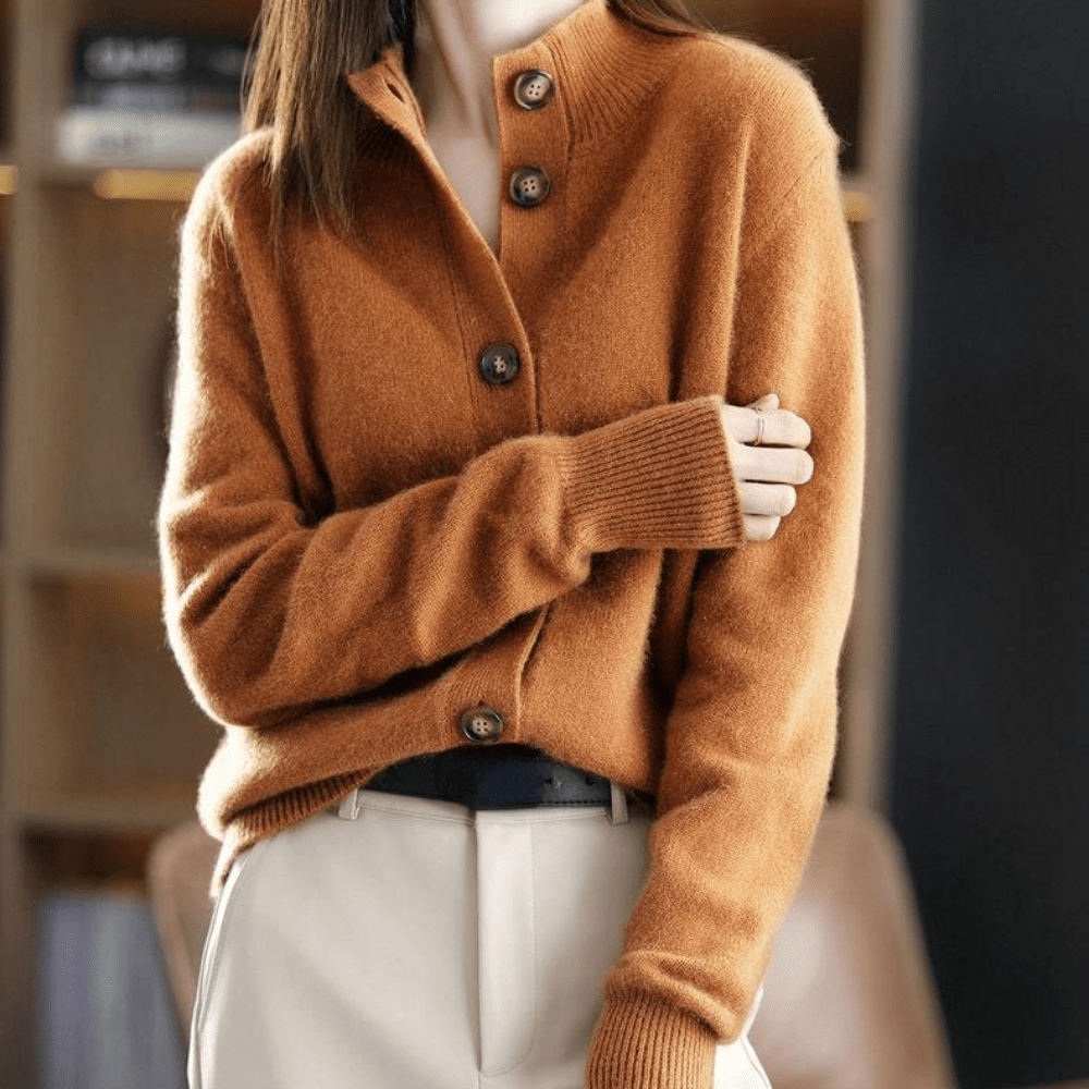 Femme portant un cardigan en laine marron avec boutons, manches longues, sur un pantalon beige. Mode automne-hiver, style élégant et confortable.