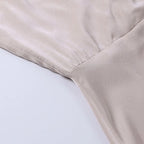 Robe en satin beige, tissu doux et brillant, couture élégante, mode féminine, vêtement chic, détail de texture luxueuse.