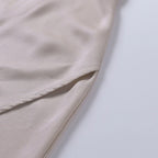 Robe en satin beige, tissu doux et soyeux, couture élégante, mode féminine, vêtement chic, style minimaliste, tendance actuelle.