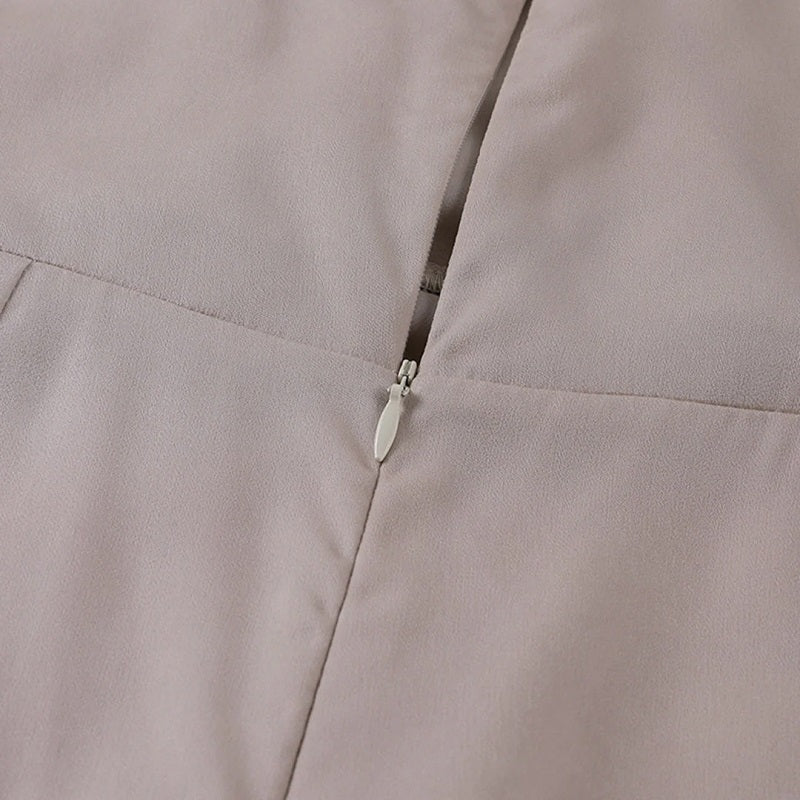 Robe beige avec fermeture éclair discrète, tissu doux et élégant, mode féminine, vêtement chic, détail couture, style moderne.