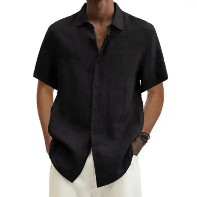 Chemise noire à manches courtes pour homme, style décontracté, col ouvert, portée avec un pantalon blanc. Mode masculine élégante et moderne.