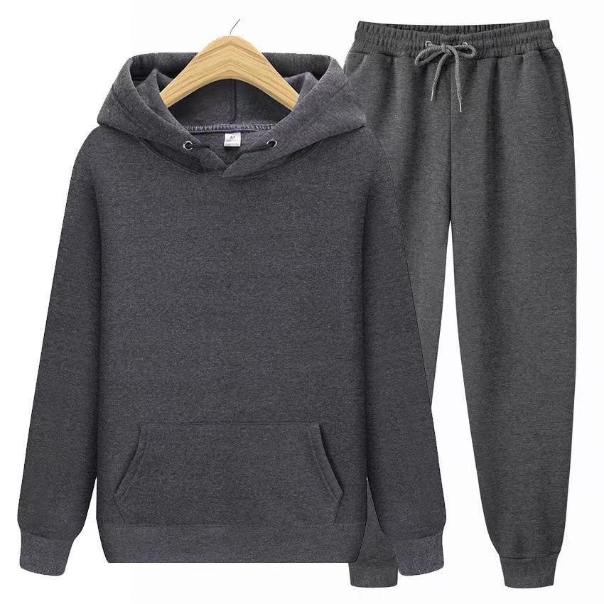 Sweat à capuche gris et pantalon de jogging assorti sur cintre en bois. Ensemble confortable, mode décontractée, vêtements de sport unisexes.