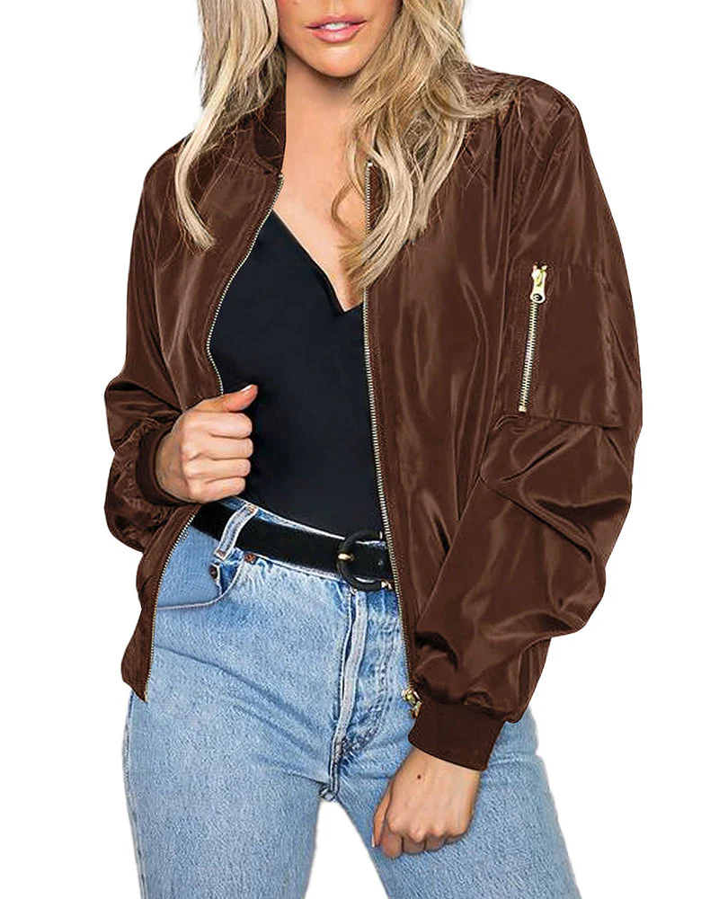 Femme portant un blouson bomber marron, t-shirt noir et jean bleu. Mode décontractée, tendance automne, style urbain chic.