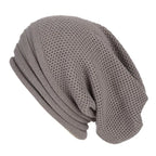 Bonnet en tricot gris, style slouchy, texture gaufrée, accessoire de mode hiver, unisexe, tendance et confortable.