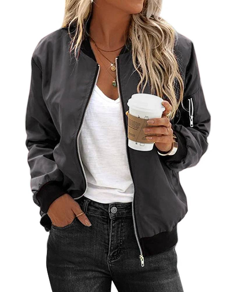 Femme portant un blouson noir, t-shirt blanc, jeans foncé, tenant un café à emporter. Mode décontractée, style urbain, look moderne.