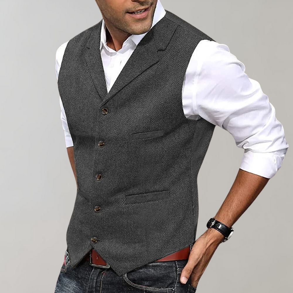 Homme portant un gilet gris élégant sur chemise blanche, style décontracté chic, mode masculine, tenue moderne, jeans, montre-bracelet.