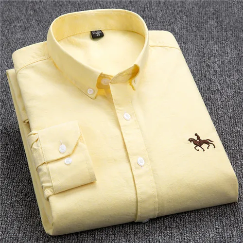 Chemise homme jaune en coton, col boutonné, logo cavalier brodé, manches longues, posée sur fond gris. Mode élégante et décontractée.