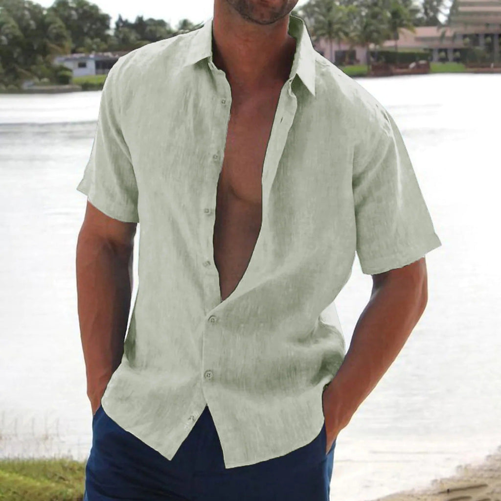 Homme portant une chemise en lin vert clair, manches courtes, devant un lac. Mode estivale décontractée, style plage, chemise ouverte.
