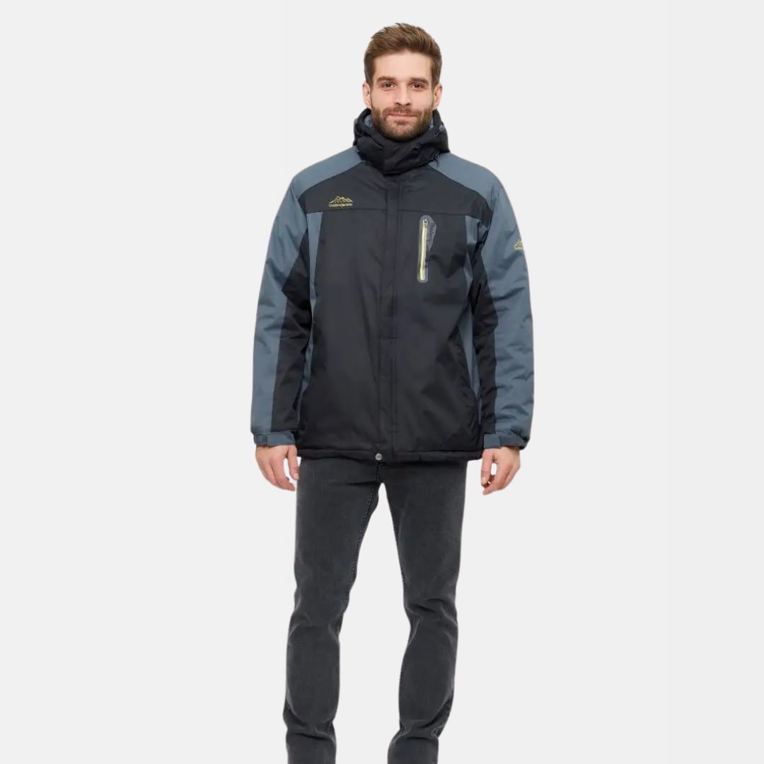 Homme portant une veste de ski noire et grise avec capuche, fermeture éclair et logo, sur fond blanc. Mode hiver, vêtements de sport.