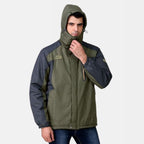 Homme portant une veste imperméable verte et grise avec capuche, idéale pour randonnée et activités extérieures. Mode outdoor, vêtement chaud.