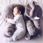 Bébé dormant paisiblement sur un coussin éléphant en peluche gris, vêtement blanc, chambre douce, confort, sommeil enfantin, peluche éléphant.