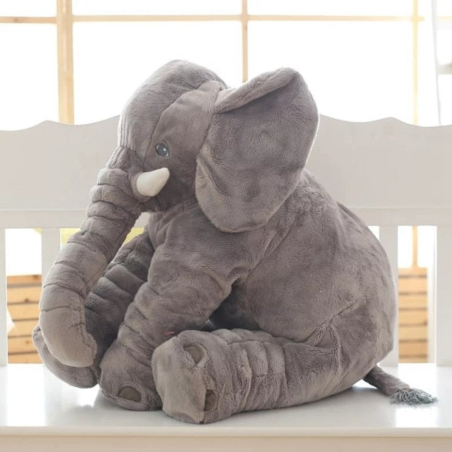 Peluche éléphant gris assis sur une chaise blanche, jouet doux et câlin pour enfants, décoration chambre bébé, cadeau idéal.