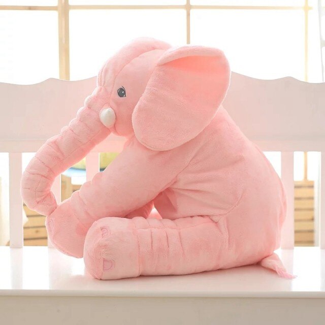 Éléphant en peluche rose assis sur une chaise blanche, jouet doux et câlin pour enfants, décoration de chambre, cadeau idéal.