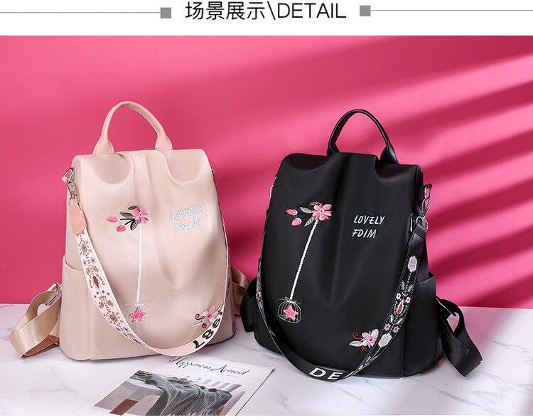 Deux sacs à dos élégants avec broderies florales, l'un rose et l'autre noir, posés sur un fond rose. Accessoires tendance et design moderne.