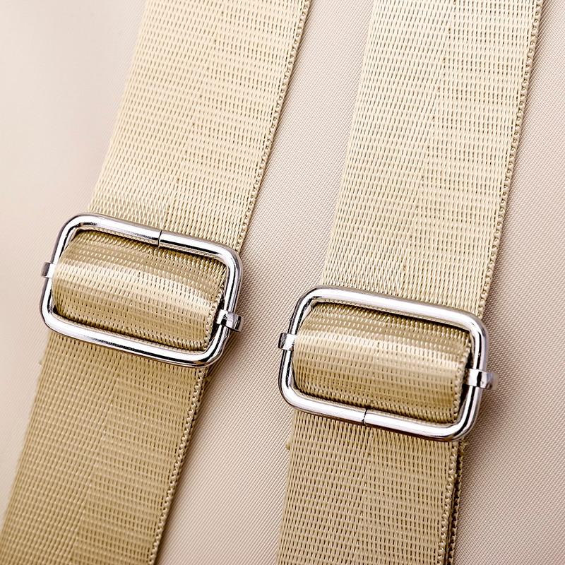 Boucles métalliques argentées sur sangles en nylon beige, gros plan. Accessoires de mode, ceinture réglable, design élégant et moderne.