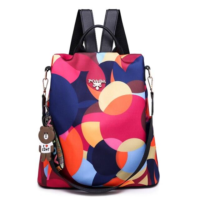 Sac à dos coloré avec motifs géométriques, porte-clés ours, bretelles noires. Accessoire mode tendance, idéal pour école ou loisirs.