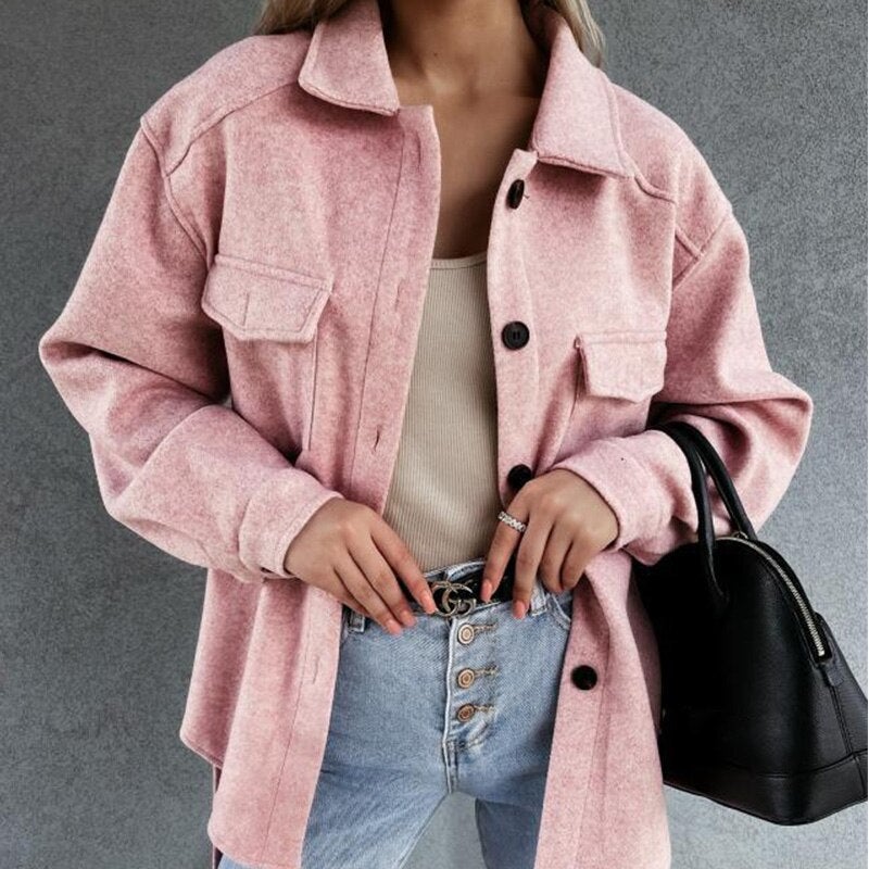 Femme portant une surchemise rose en laine, débardeur beige, jean taille haute, tenant un sac noir. Mode automne, style décontracté chic.