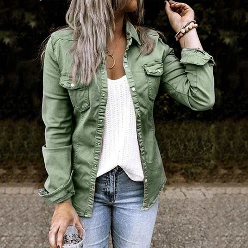 Femme portant une chemise verte en jean, un débardeur blanc et un jean bleu, tenant un verre. Mode décontractée, style automne, tendance féminine.