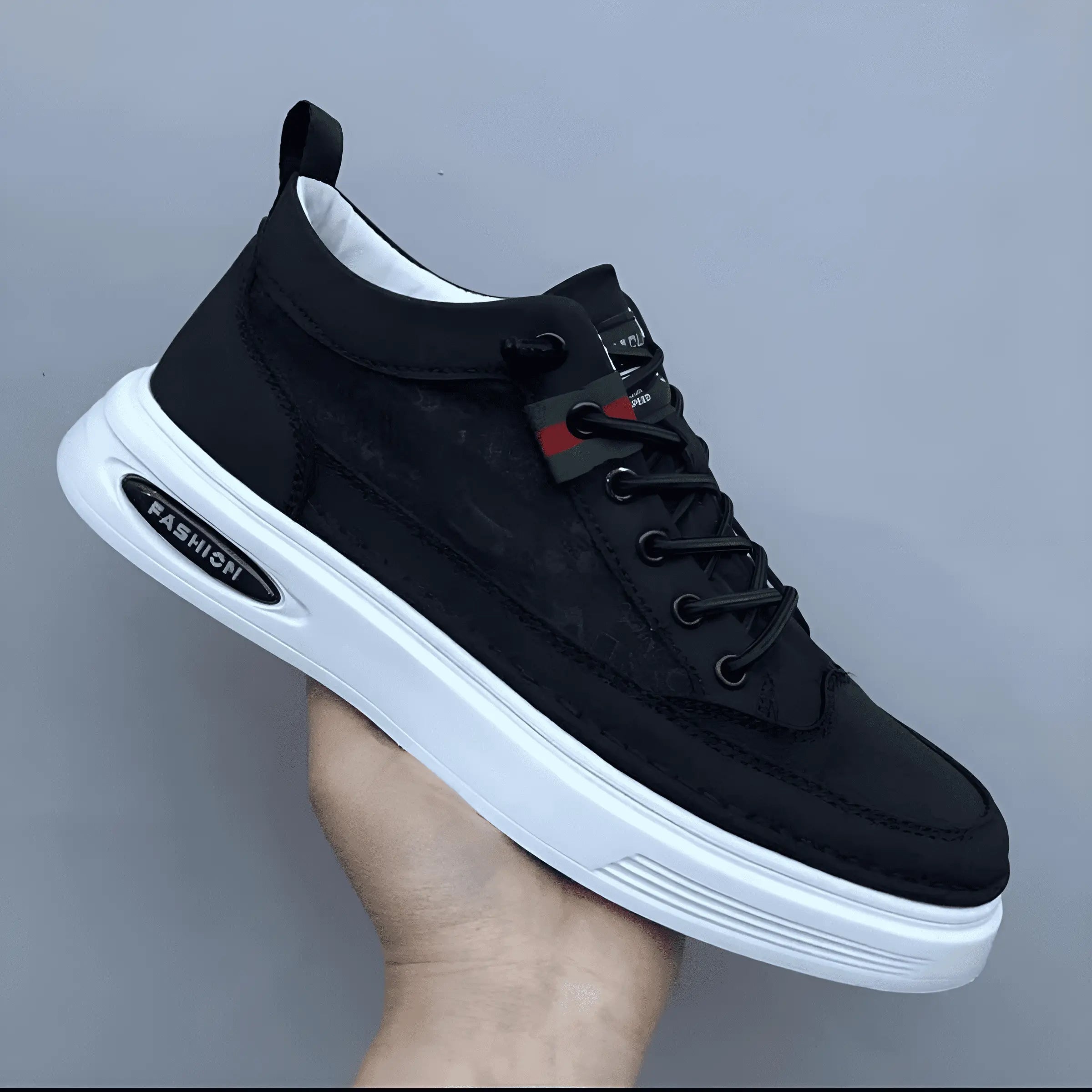 Chaussure de sport noire pour homme avec semelle blanche épaisse, lacets noirs et étiquette "Fashion". Design moderne et tendance.